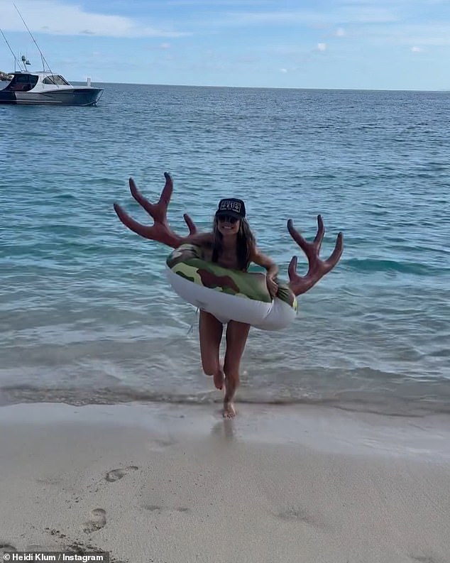 Heidi showed off her dazzling white smile as she ran out of the sea in a rubber reindeer ring