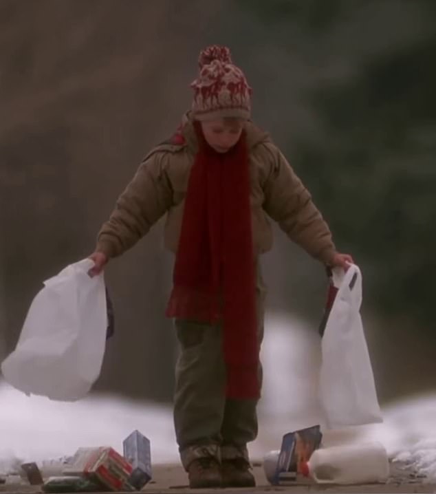 As the eight-year-old boy strolls down the sidewalk, the two bags rupture at the exact same time, spilling the entire contents of the bag onto the ground