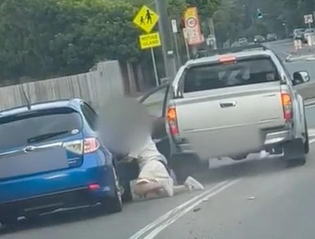 A woman was run over by a Ute after throwing an object at the driver during a terrifying road accident (pictured)