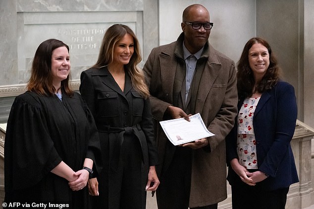 Former First Lady Melania Trump stands next to Judge Elizabeth Gunn (left) and US Archivist Colleen Shogan (right) as they pose for photos with a newly sworn citizen after a naturalization ceremony at the National Archives