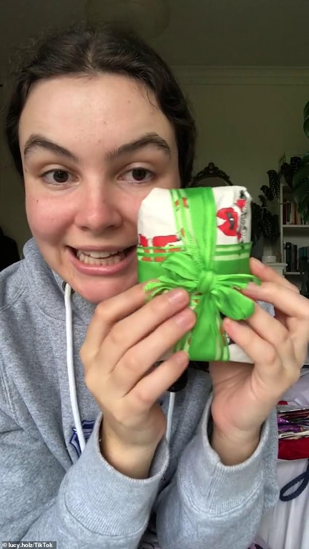 A young woman wraps her Christmas presents every year without tape so she can reuse the wrapping paper