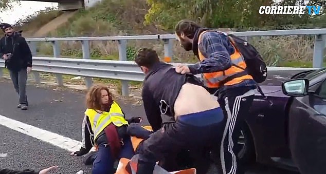 The driver of the BMW was seen dragging a male protester from his car