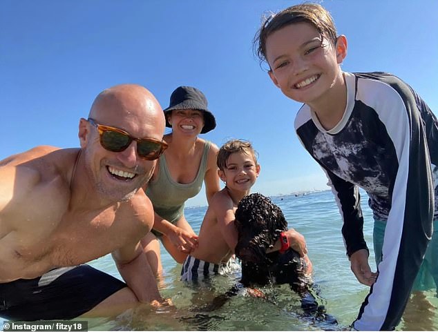 Fitzy, 47, plans to move to Adelaide with his family early next year but will continue to present the show remotely.  (Fitzy pictured with wife Belinda and their sons Hewy and Lenny)