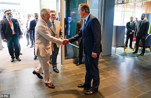 King Charles is greeted by Foreign Secretary Lord Cameron as he arrives to meet students at the Heriot-Watt University Dubai Campus during Cop28