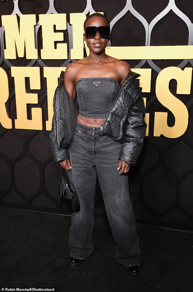 Lupita flashed her sculpted abs and stole the spotlight in the dark gray strapless top, matching pants and jacket