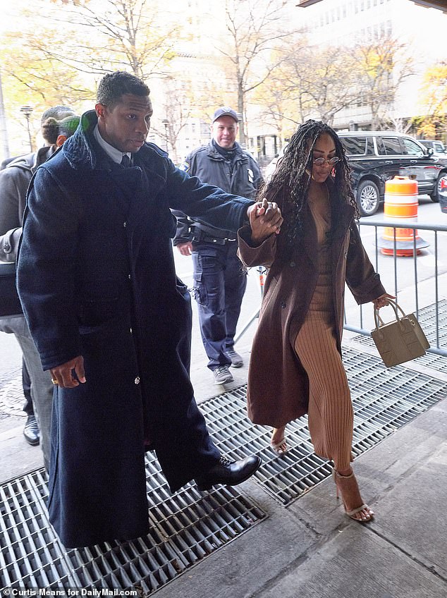 Majors and his partner, Meagan Good, dodge sidewalk grilles in New York as they arrive at the courthouse on Tuesday