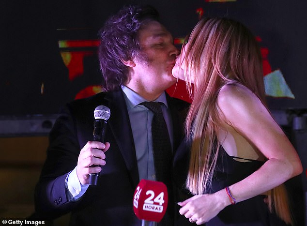 Argentina's newly elected president, Javier Milei of La Libertad Avanza, kisses his girlfriend and actress Fatima Florez after the polls closed during the presidential elections on November 19