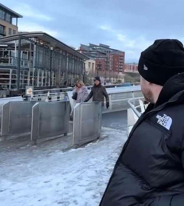 This unsuspecting couple was unaware of the chunk of ice before it was too late, as the woman soon slipped across the ground