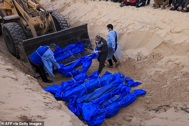 The shrouded bodies of Palestinians killed in northern Gaza who were captured by Israel and later released will be buried in a mass grave in Rafah, southern Gaza Strip, on December 26, 2023.