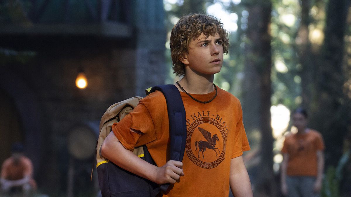 Percy Jackson (Tyler Scobell) stands wearing his Camp Half-Blood shirt