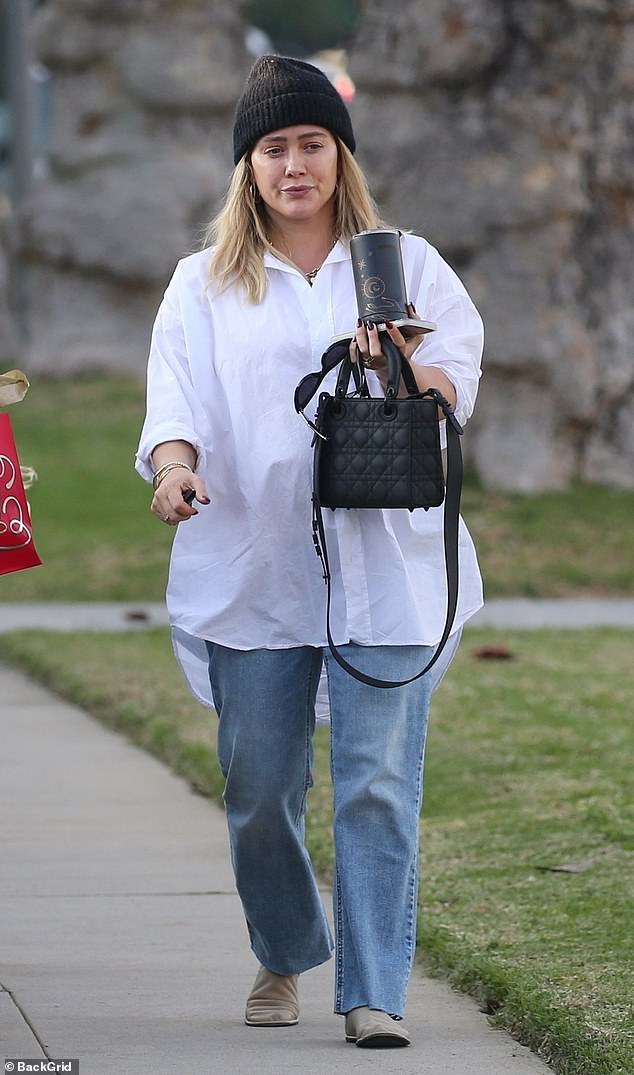 Hilary Duff showed off her timeless maternity style on Thursday as she covered up her burgeoning baby bump in a classic white button-up shirt in Los Angeles