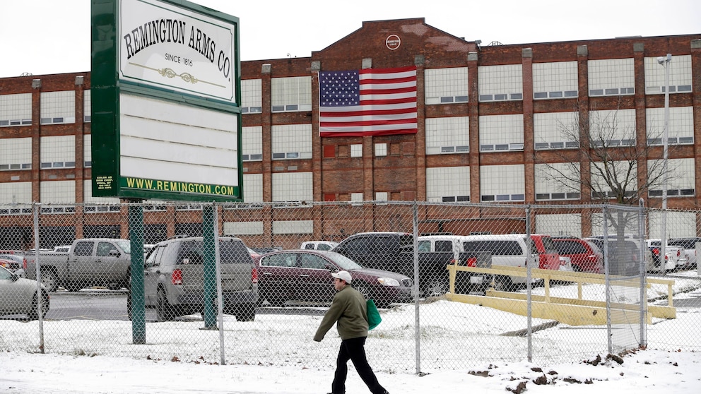 FILE – A man walks past the Remington Arms Company, January 17, 2013, in Ilion, NY.  The upstate New York gun factory, with a history dating back to the 19th century, is expected to close in March 2024, according to a letter from the company to union officials on Thursday, Nov. 30, 2023. (AP Photo/Mike Groll, File)