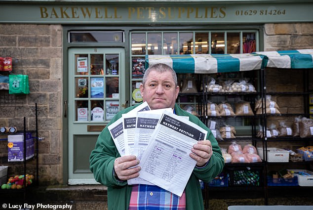 Campaign: Mark Wakeman, with a petition to stop the closure of NatWest, outside his pet shop in Bakewell
