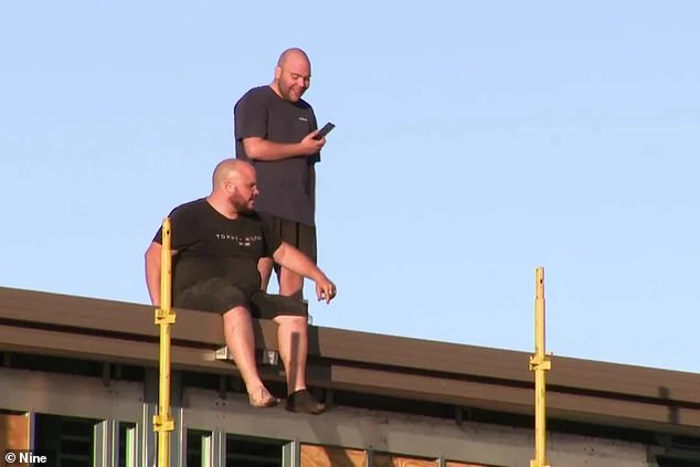 Two men (pictured) were arrested after refusing to get off the roof of a building at a construction site in Perth