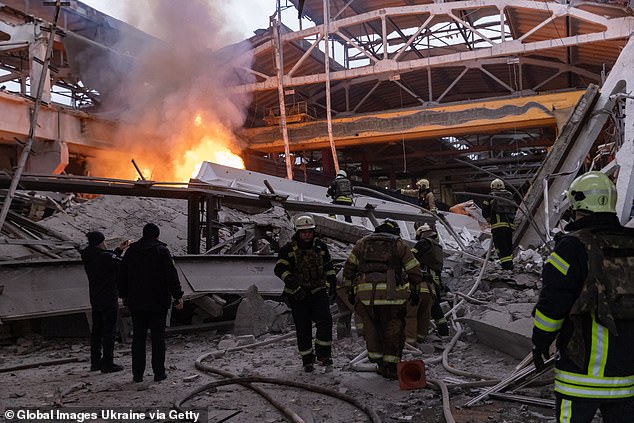 Firefighters extinguish a fire in a damaged business after a Russian missile attack on December 29, 2023 in Kharkiv, Ukraine