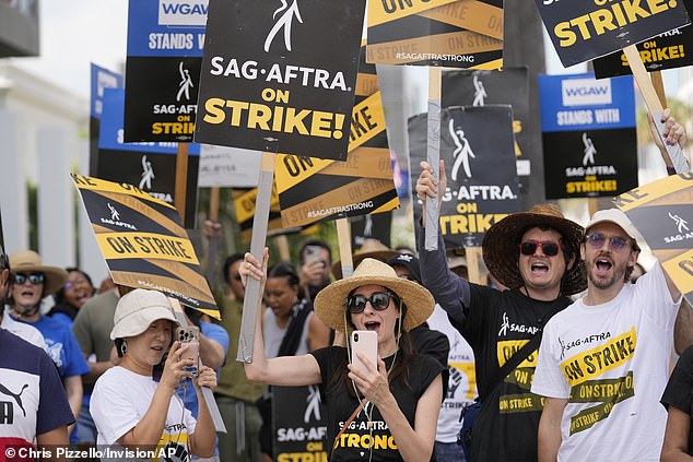 People protesting on behalf of the Screen Actors Guild-American Federation of Television and Radio Artists carry signs outside Netflix on September 27, 2023 in Los Angeles