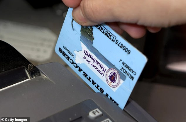 A cashier in Massachusetts swipes a food stamp debit card issued by the Supplemental Nutrition Assistance Program (SNAP).