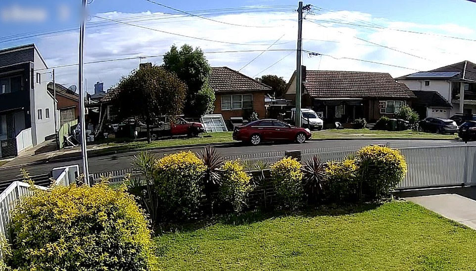 The masked man is seen slipping next to the red ute where Toufik and Salim Hamze were sitting on the morning of October 20, 2021