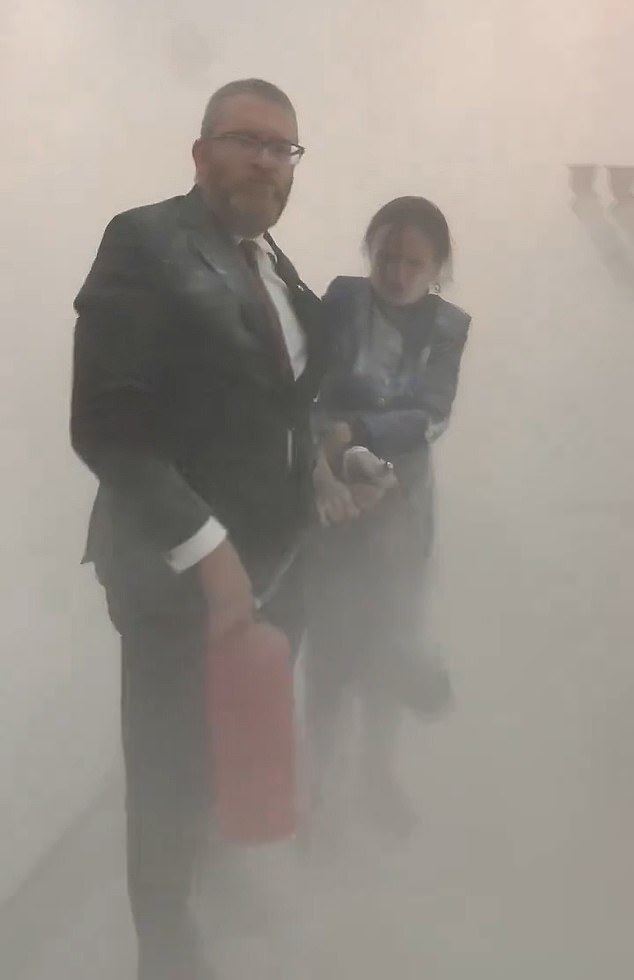 Seconds later, a female official desperately tries to grab the fire extinguisher from Braun's hands – only for the far-right MP to shoot her in the face with white power