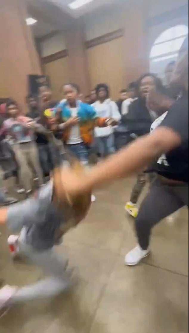 A now-viral video shows a shocking brawl broke out at an Alabama high school, with two women fighting before a group of students jumped in