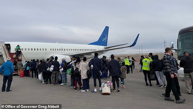 Migrants line up in El Paso on Tuesday to board planes to Chicago