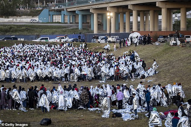 Thousands of migrants wrapped in silver thermal blankets, many hoping to seek asylum in the US, have gathered under a bridge in Eagle Pass, Texas, waiting for their chance to surrender to US Border Patrol.