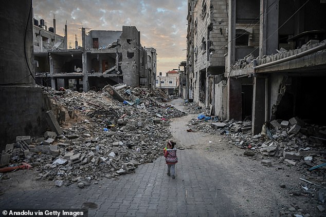A child walks among the rubble of the destroyed buildings in Gaza