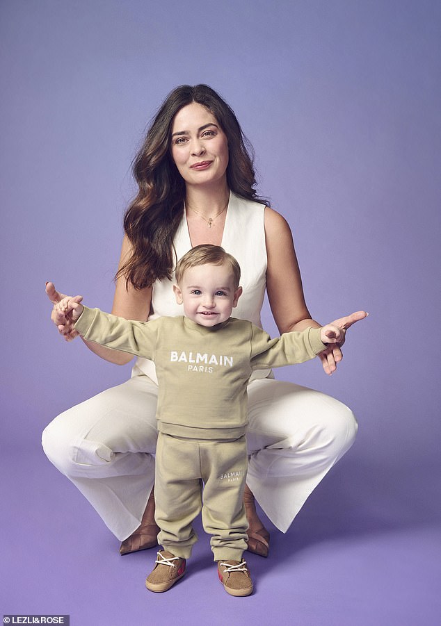 Baby stylist Tryce Vane Percy is pictured with baby model River Hind, who is wearing a jumper from designer Balmain (£105) and matching tracksuit bottoms (£84).