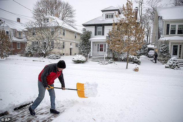 Americans can invest in making their homes more energy efficient this winter and claim up to $3,200 in tax credits.  The photo shows a man shoveling snow outside his home in Providence, Rhode Island