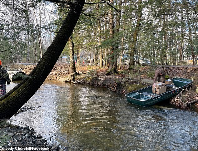 Jody Churchill shared a photo on Facebook on December 19 of UPS driver Ryan Long crossing a washed-out section of Pond Road in Mercer, Maine, in a boat.