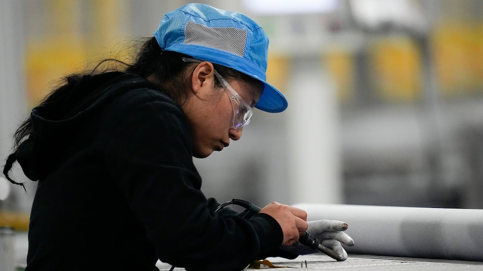 File - An employee works at the Hanwha Qcells Solar factory in Dalton, Georgia on October 16, 2023.  On Tuesday, the Labor Department will report on vacancies and employee turnover for October.  (AP Photo/Mike Stewart, File)