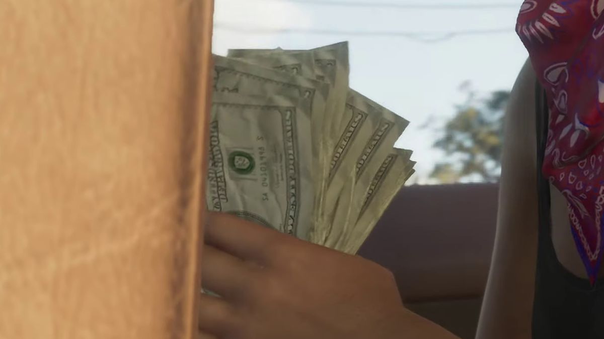 A close-up of a woman's hand holding a stack of crumpled $20 bills.