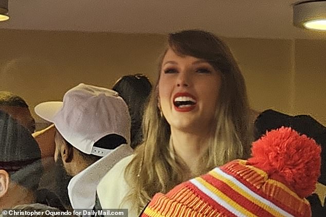 Swift laughs as she watches the first half of Sunday's rematch of last year's AFC title game