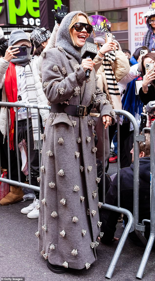 She was stylish in a fluffy gray scarf and shiny black sunglasses