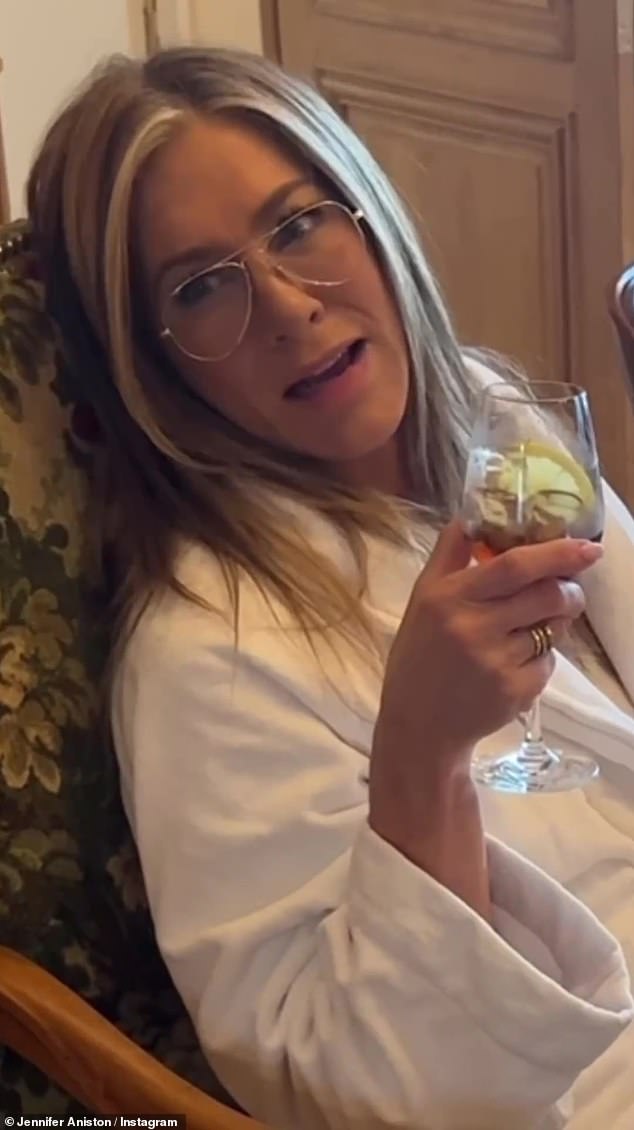 In one clip, Jen relaxed in a soft white robe while wearing aviators