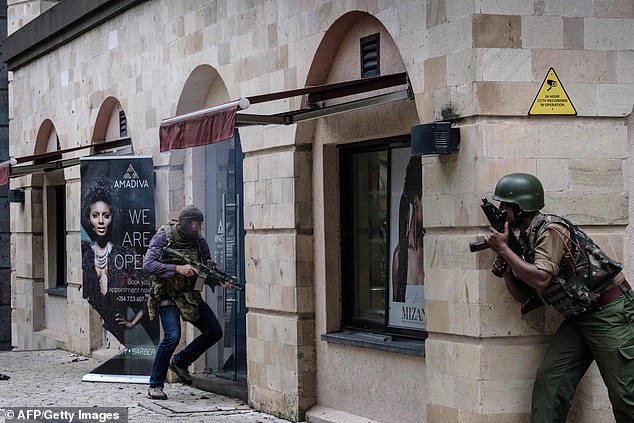 Craighead breaks down a hotel door while wearing a camouflage flak jacket and balaclava and armed only with an assault rifle