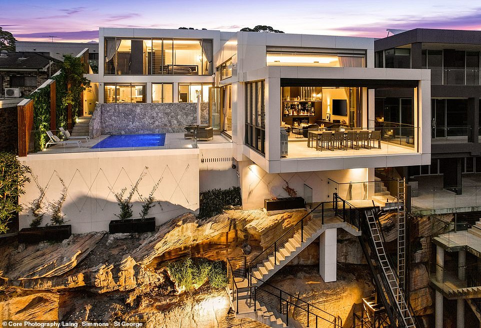 Perched on the edge of a cliff overlooking the Georges River lies an extravagant mansion with an epic man cave, waterfront terrace and opulent master suite