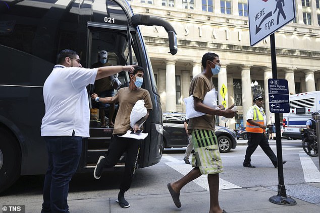 Migrants are led from one bus to another after arriving in Chicago from Texas on September 9, 2022