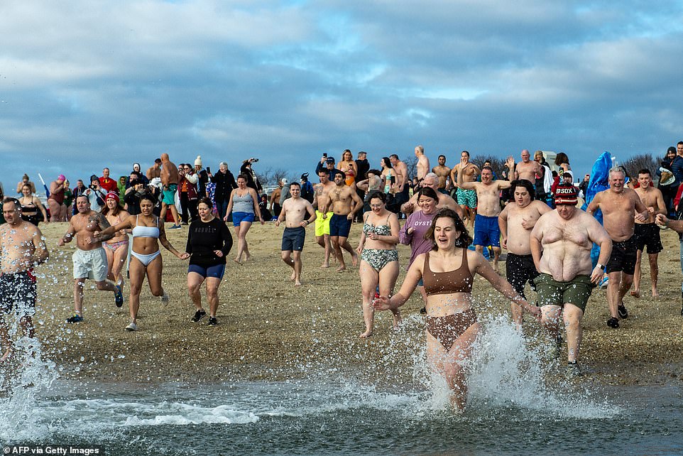 Bostonians run toward the ocean waters during the Polar Bear Plunge on New Year's Day.  According to the National Oceanic and Atmospheric Administration (NOAA), the temperature in Boston Harbor was a chilly 44.6 degrees Celsius.