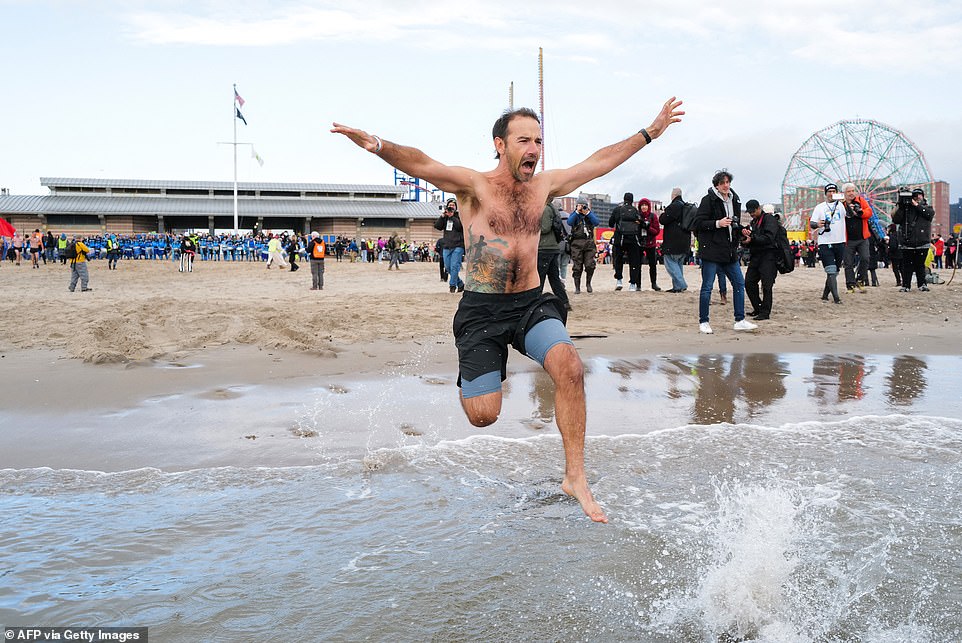 A swimmer is seen mid-air in the icy waters of Coney Island