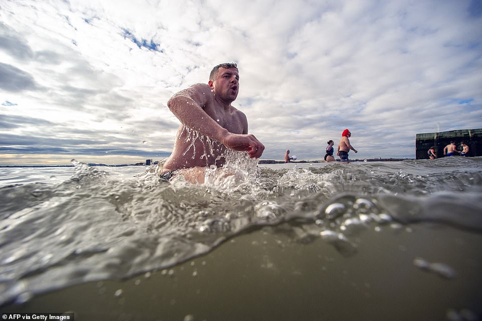 A participant shows just how cold the water temperature really is by the look on his face during the L-Street Brownies cold water dive at M Street beach