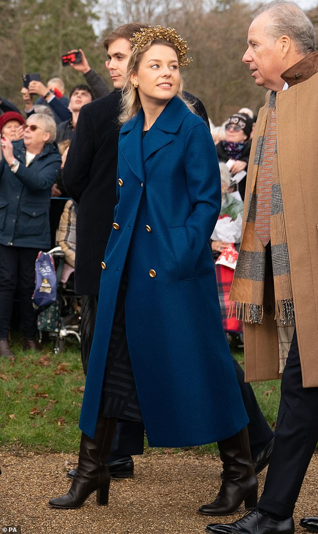 Lady Margarita's gold headband accentuated the contrasting blue coat and black boots