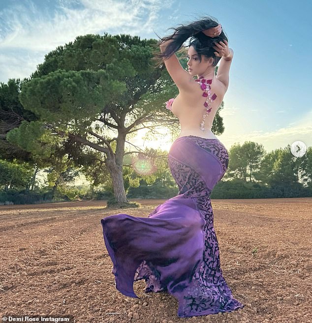 Demi put on a daring show as she posed in a field in a flowing purple maxi skirt that showed off her hourglass figure