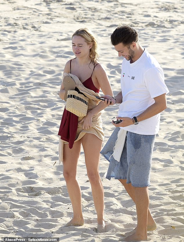 Kimberley laughed with her friend as she left the beach, wrapping herself in a towel