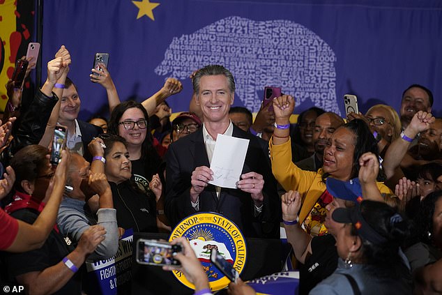 California Governor Gavin Newsom signs the fast food bill into law surrounded by fast food workers at SEIU Local 721 in Los Angeles in September 2023.  The minimum wage is now $16.00