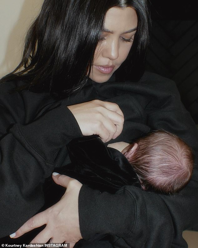 In one image, Kourtney breastfed Rocky while wearing a black hoodie and matching sweatshirt