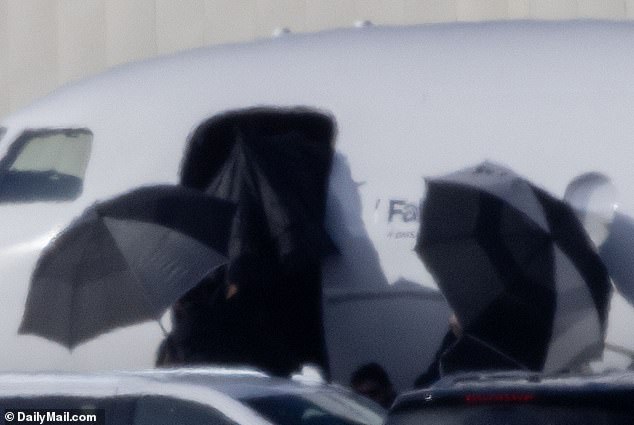 The Anti-Hero hitmaker boarded a chartered plane while being protected by umbrellas