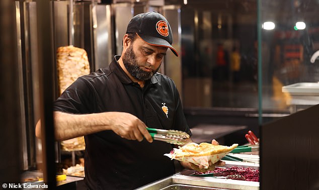 German Doner Kebab branch manager Shah Zandi said he was 'proud' to help Littler to victory.  Pictured: a worker making a kebab in the Islington store