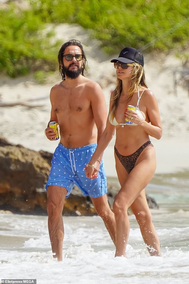 Heidi held hands with Tom as they enjoyed a walk along the beach, eventually dipping their legs into the ocean