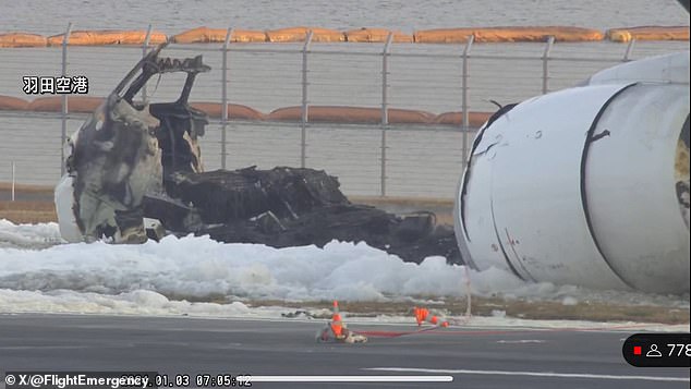 Foam surrounds the burned-out wreckage of the plane the morning after it collided with a Coast Guard plane and caught fire